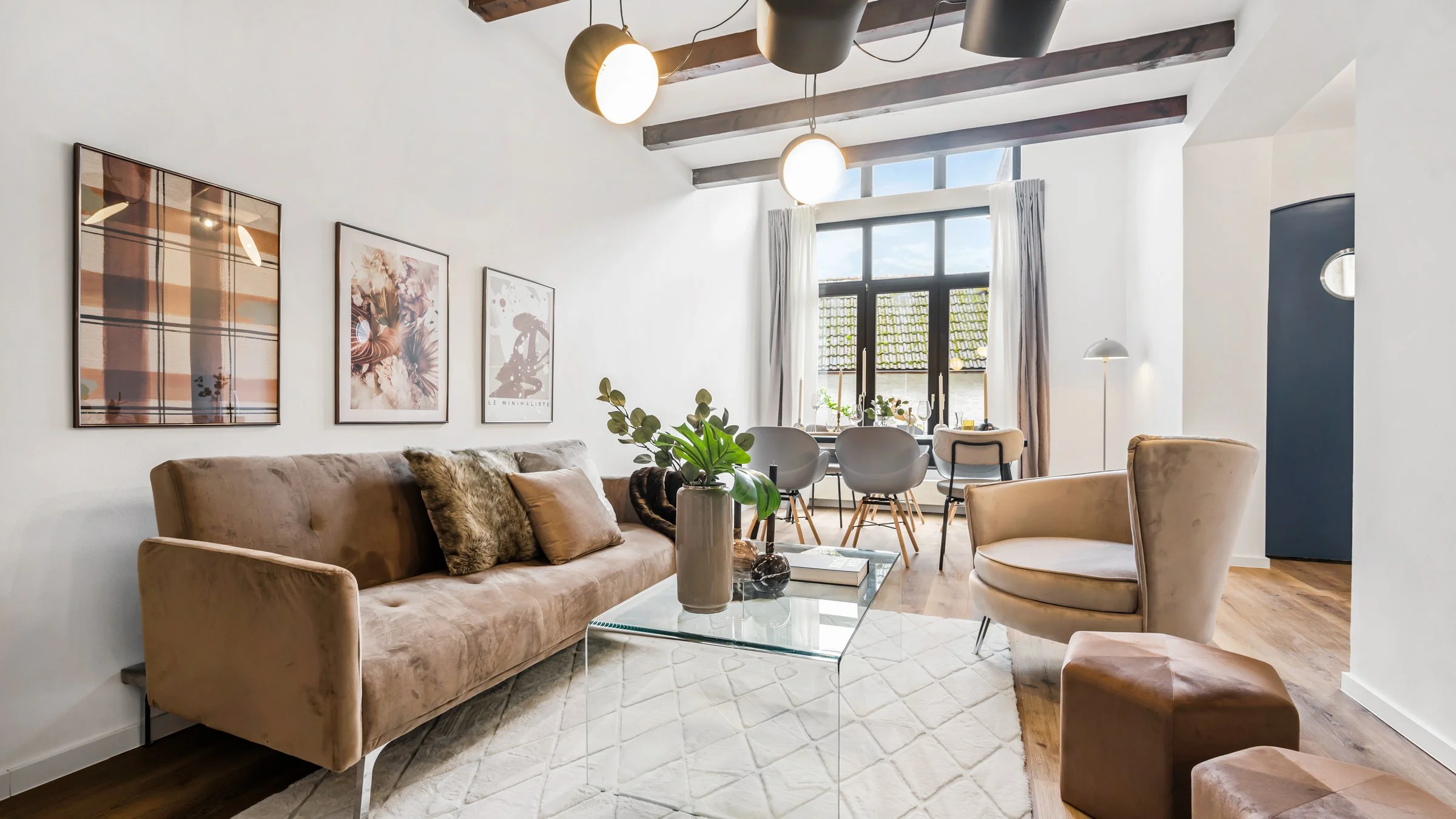 Hell eingerichteter Wohnbereich mit Sofa, Sesseln und Essplatz