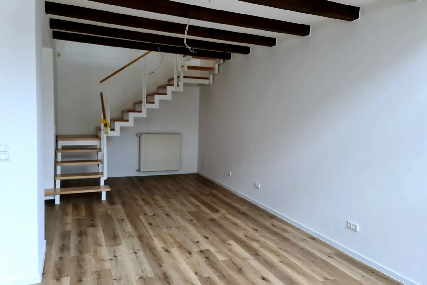 Leerer Wohnraum mit offener Treppe, ohne Möblierung