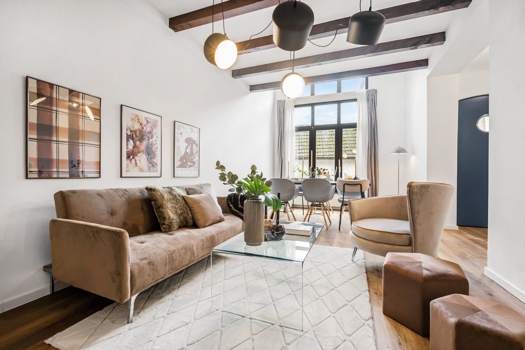 Wohn- und Essbereich mit Sprossenfenster, eingerichtet mit Sofa, Sessel und Esstisch