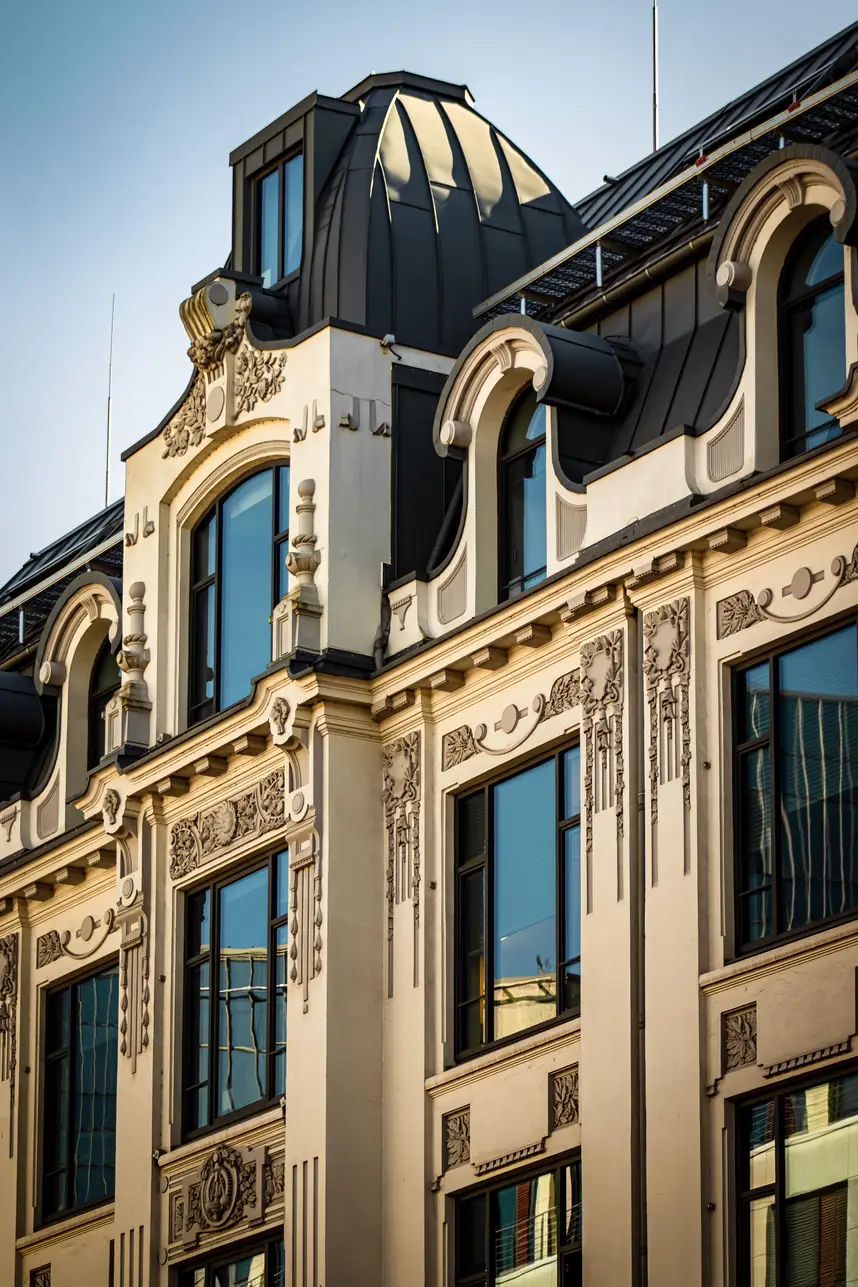 Jugendstilfassade mit Erkern und Kuppel vor blauem Himmel